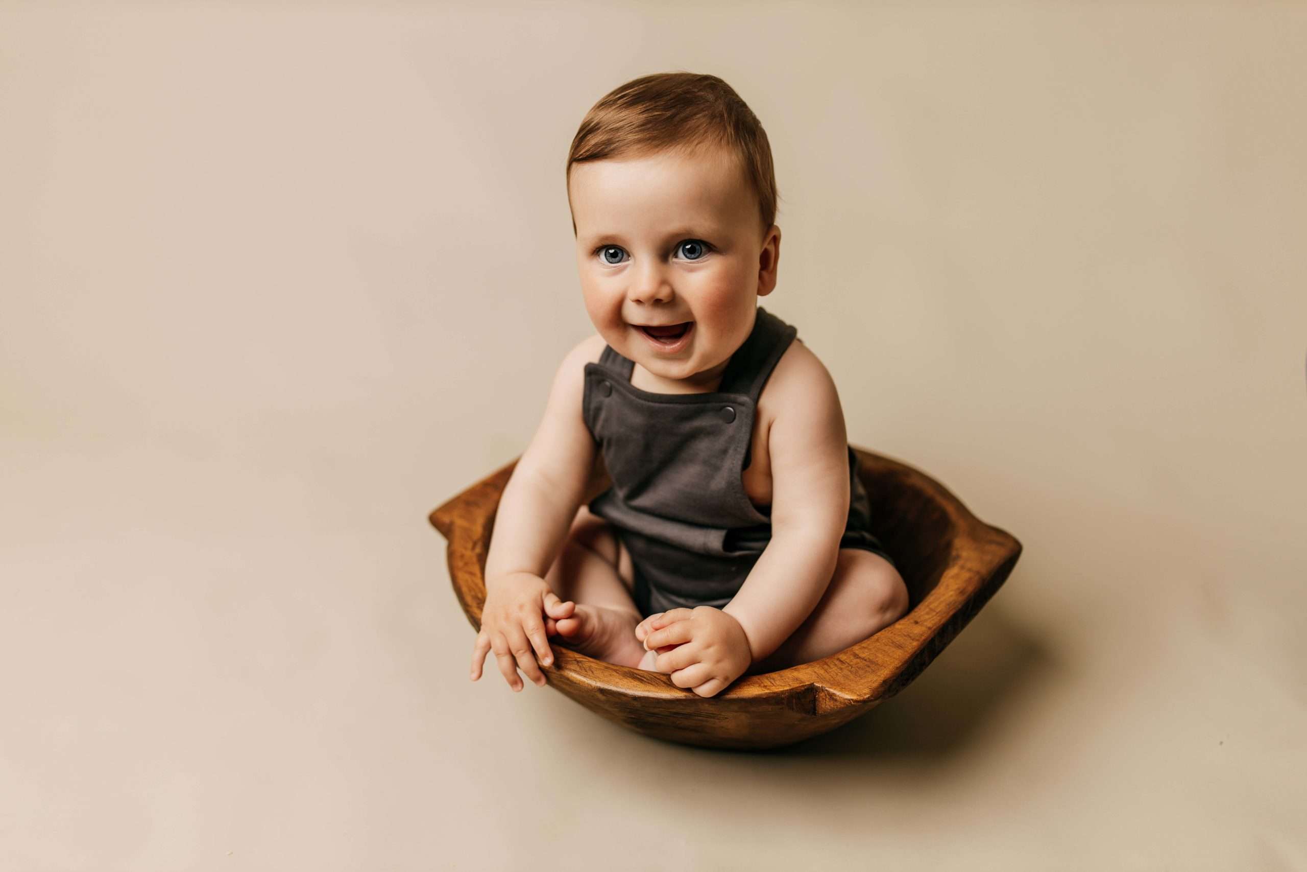 six month old sitting in dough bowl on tan backdrop