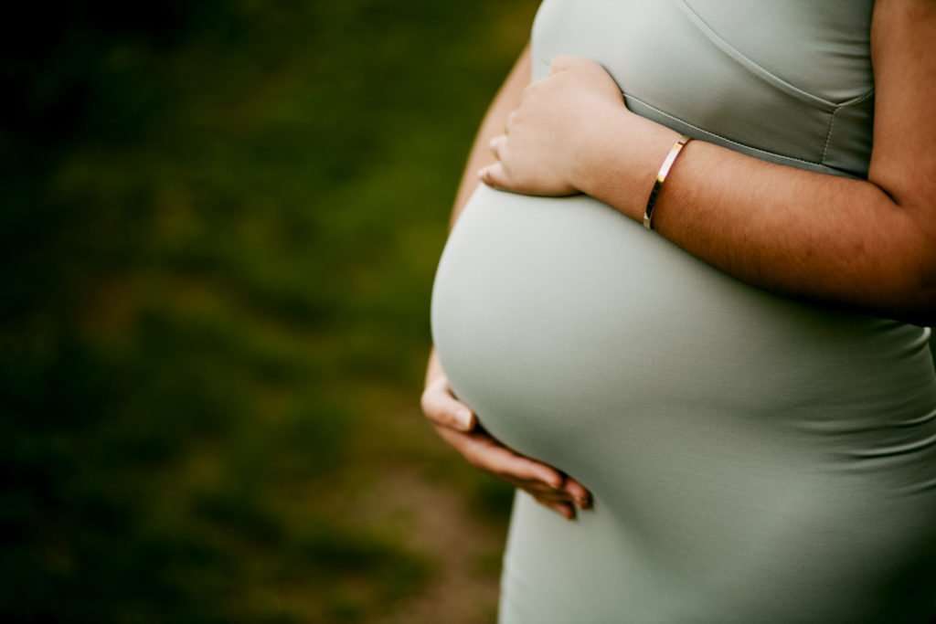 Cave Springs maternity photography session focusing on baby belly with mom cradling her belly