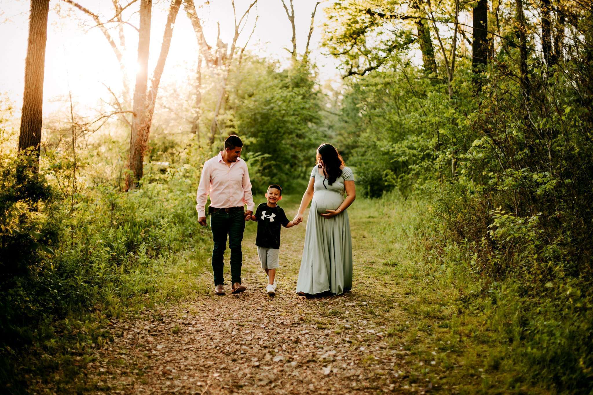 Family walking down dirt path while holding hands