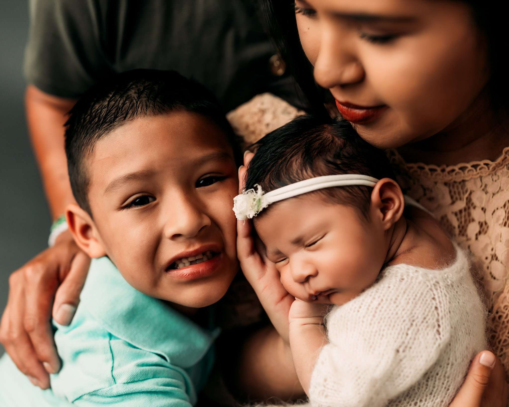 brother cuddling with baby sister in photography studio