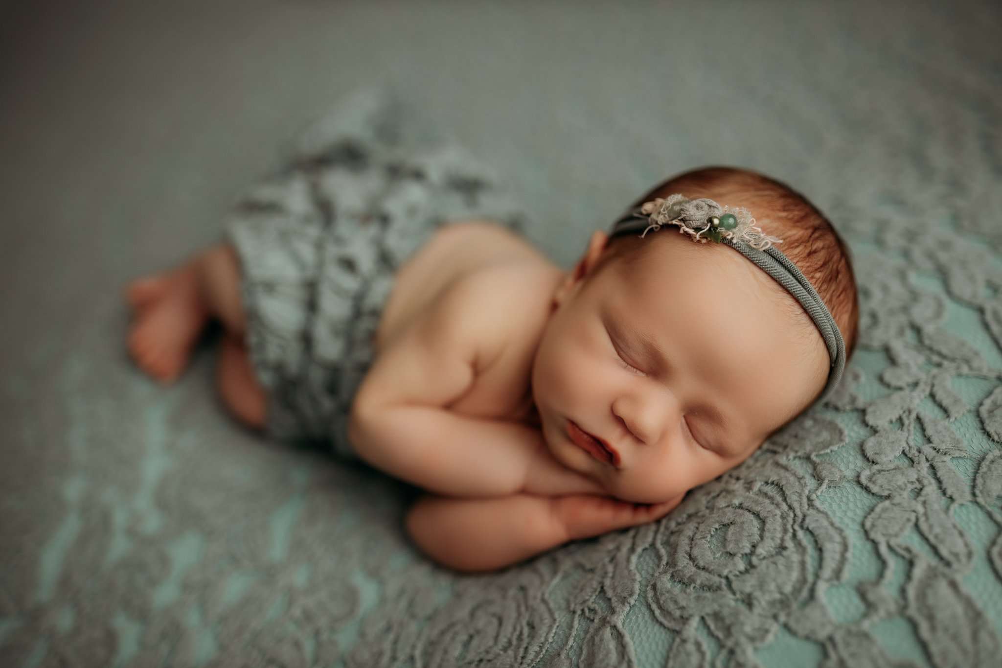 nwa newborn sleeping in side laying pose while facing camera sleeping