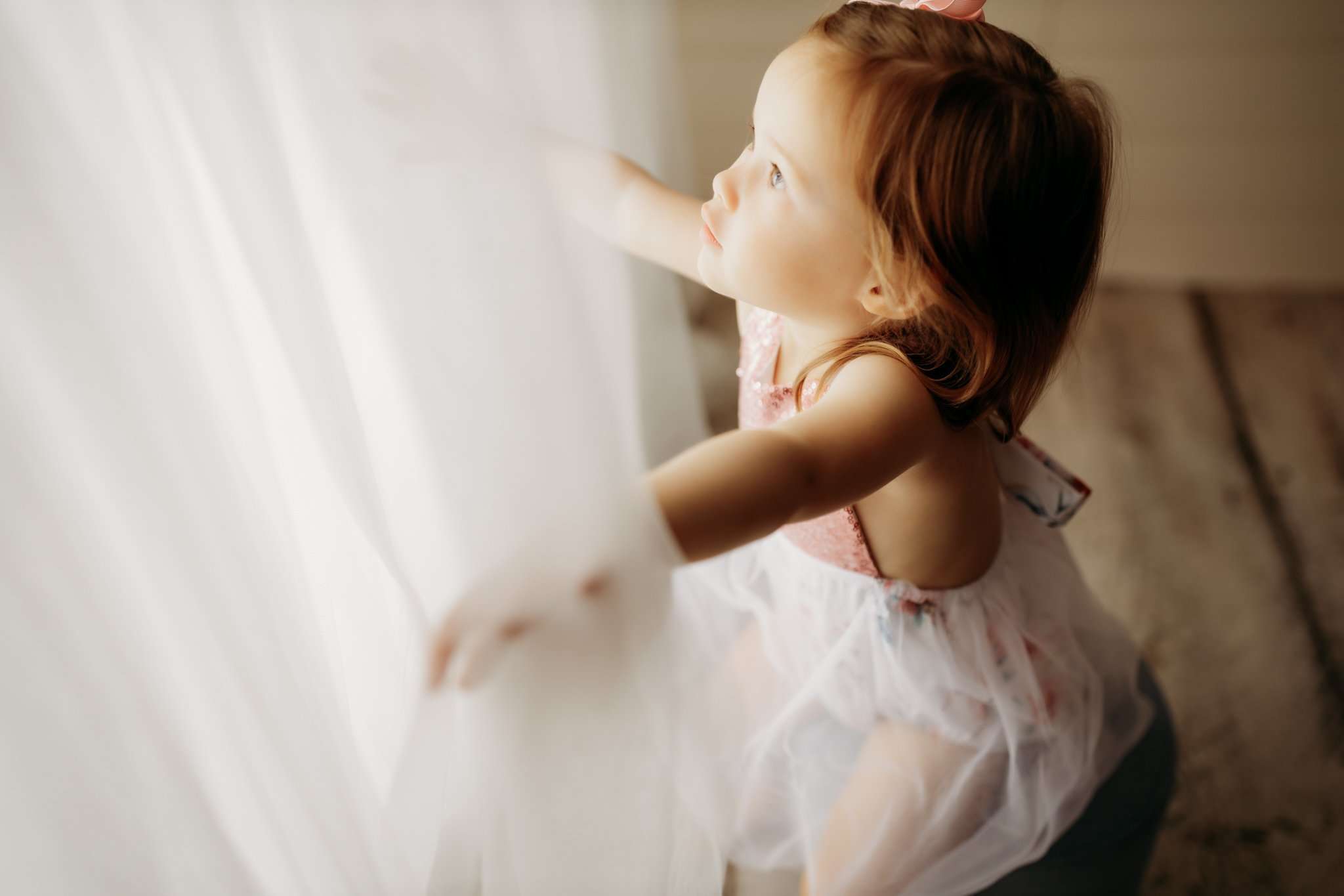 nwa childrens photography with child looking through faux window in studio