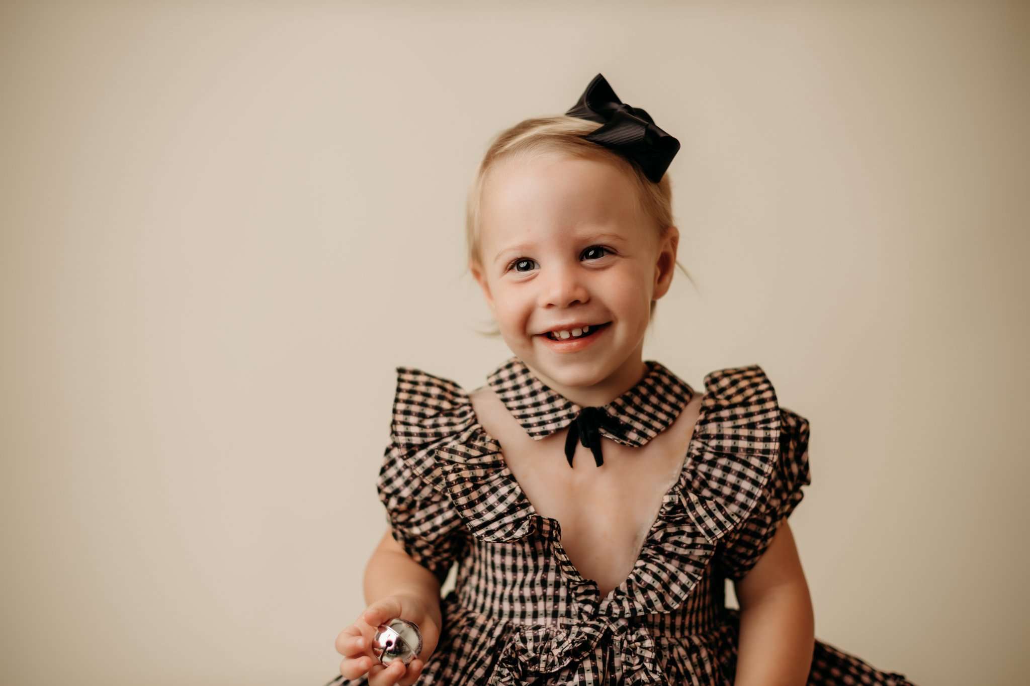 nwa childrens photography in studio with child smiling at camera against a cream backdrop and wearing a family heirloom dress